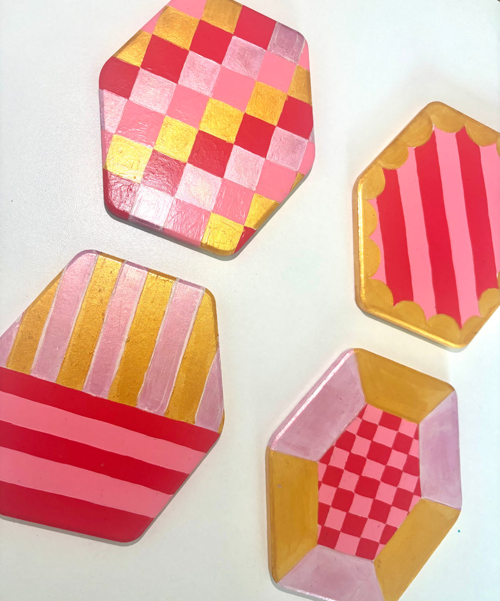 Set of 4 geometric pink and gold coasters, hexagonal shape.
