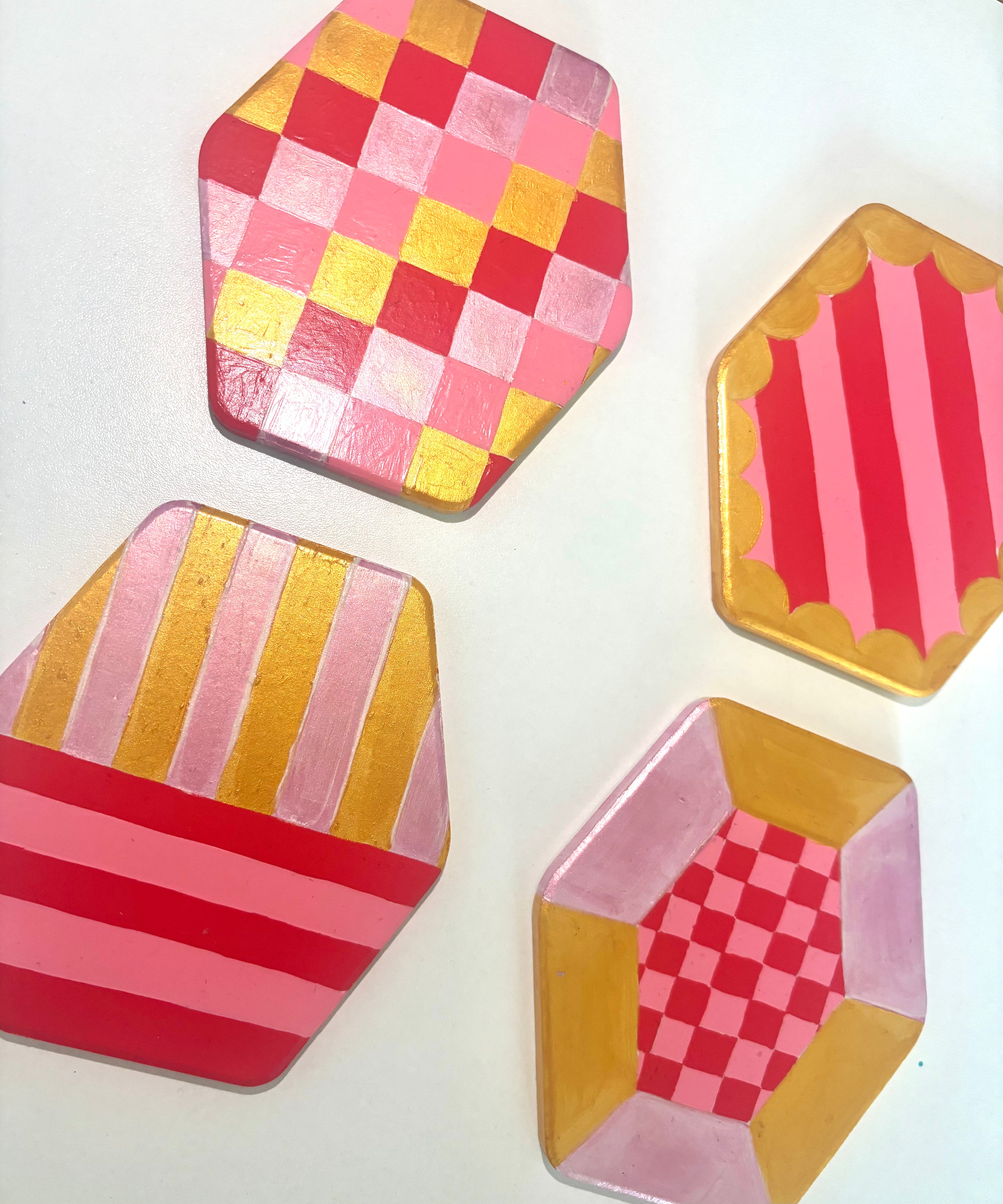 Set of 4 geometric pink and gold coasters, hexagonal shape.