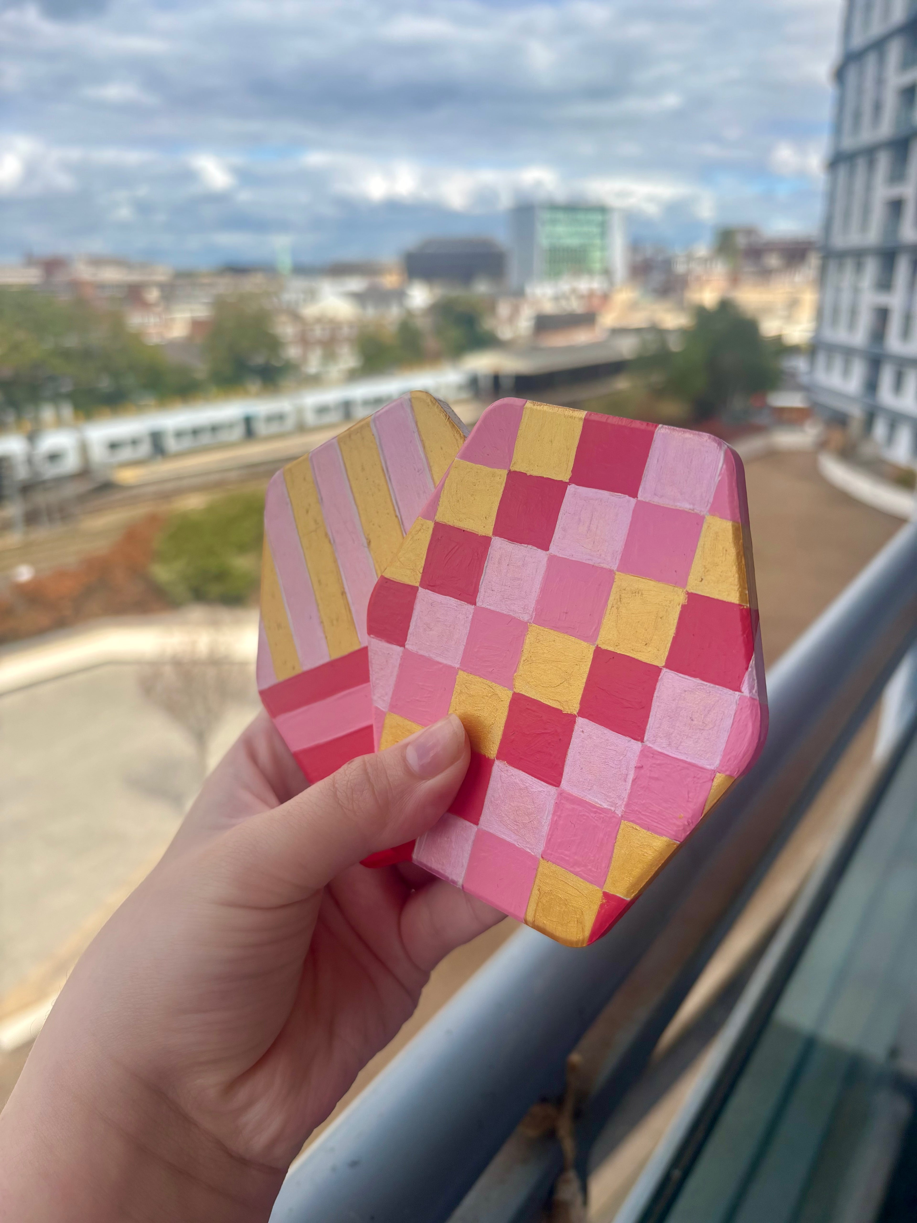 Set of 4 geometric pink and gold coasters, hexagonal shape.