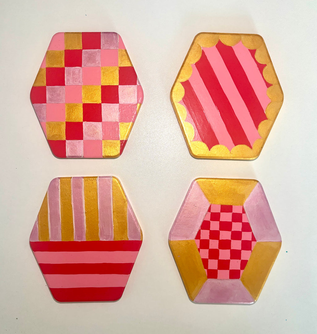 Set of 4 geometric pink and gold coasters, hexagonal shape.